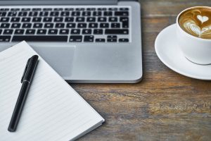 mesa com notebook e cafe